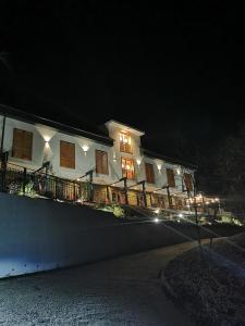 SukoróIllaberek Turistaház的夜晚有灯的大白色房子
