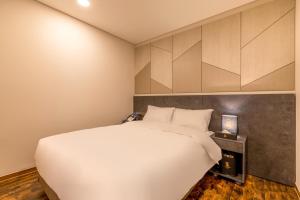 高阳市Urban-Est Hotel的卧室配有白色的床和墙壁