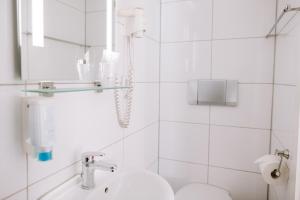杜塞尔多夫Boutique Hotel Villa Oberkassel的白色的浴室设有水槽和卫生间。