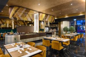 布达佩斯Emerald Hotel的一间带桌椅的餐厅和一间酒吧