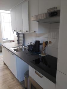 兹沃勒Stadslogement 8的厨房配有白色橱柜和黑色台面
