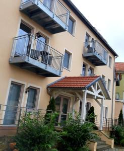 柯尼希施泰因易北Luxuriöse Ferienwohnungen的公寓大楼设有阳台和凉亭。