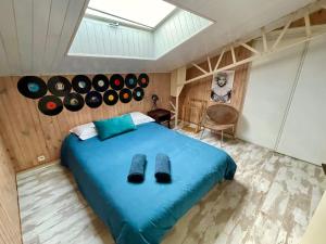 布里夫拉盖亚尔德Superbe LOFT centre-ville - Sauna - parking privé -Clim- 1 à 10personnes的卧室配有一张蓝色的床,墙上有记录