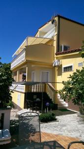 皮罗瓦茨Villa Manja的一座黄色的大建筑,前面设有阳台