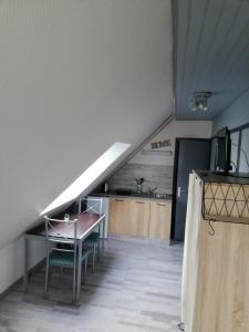 滨海埃尔芒维尔CHAMBRE STUDIO avec KICHENETTE SOLEIL DE NACRE的带桌子和厨房的楼梯间