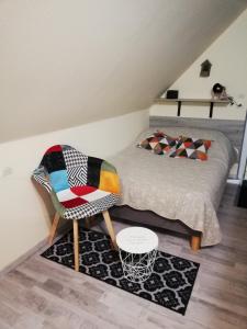滨海埃尔芒维尔CHAMBRE STUDIO avec KICHENETTE SOLEIL DE NACRE的房间里的一张床和椅子