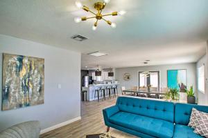 凤凰城Charming Phoenix Home with Patio about 3 Miles to Dtwn!的一间带蓝色沙发的客厅和一间厨房