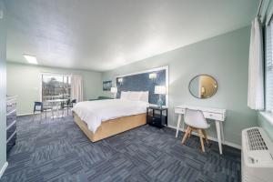 温泉城The Hamilton - Lakefront & Studio Suites, Hot Springs的一间卧室配有一张床、一张书桌和一面镜子