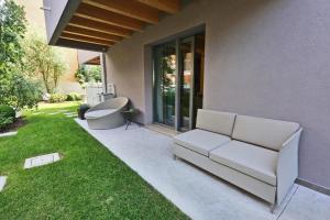 卡奥莱Ninfea Wellness & Spa Residence的坐在房子旁边的草上的一个沙发