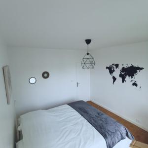 奥尔良Chambre Monde Tout confort Saint-Marceau的白色卧室配有一张床,墙上挂着世界地图