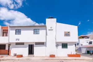 里奥阿查Hotel Casa Guajira Real的白色的建筑,有蓝色的天空