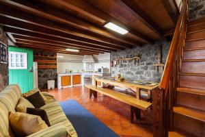 Santo Amaroholiday home, Santo Amaro, Pico, Azores的一间带木桌的客厅和一间厨房