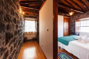 Santo Amaroholiday home, Santo Amaro, Pico, Azores的一间卧室设有一张床和石墙