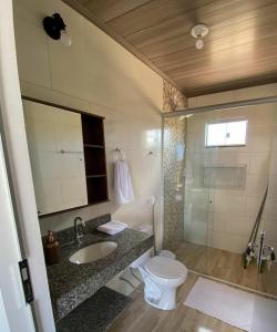 戈亚斯州上帕莱索Chalés Recanto da Baleia的浴室配有卫生间、盥洗盆和淋浴。