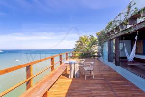 里约热内卢CLIFFSIDE - Boutique Hotel & Spa的水面上配有桌椅的木制甲板