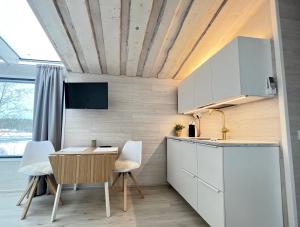 劳卡Glass Igloos by the water - Lasisviitit的厨房配有白色橱柜和桌椅
