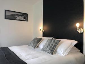 瓦洛尼Le Rocher Appart Hôtel的卧室配有白色的床和2个枕头