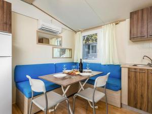 诺瓦利娅Mobile home Mediteran Superior by the pool in caravan park Strasko, Novalja的厨房里设有1间带桌椅的用餐室