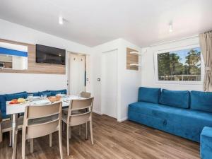 诺瓦利娅Mobile home Mediteran Superior by the pool in caravan park Strasko, Novalja的客厅配有蓝色的沙发和桌子