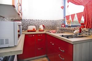 PerlinCottage, Perlin的一间配备了红色橱柜和微波炉的小厨房