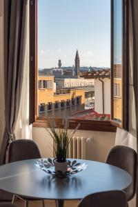 佛罗伦萨Florence Feel Apartment的配有大窗户的客房内的桌椅