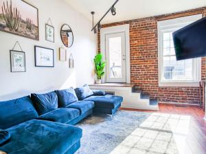 诺克斯维尔Elegant Old City Loft - Downtown的客厅设有蓝色的沙发和砖墙