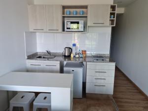 萨尔塔Aires de Capital Depto的白色的厨房配有水槽和微波炉