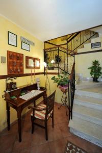 佩斯卡塞罗利Albergo Pensione Paola的客房设有书桌和带桌子的楼梯。
