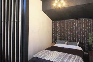 富士吉田市Fujinokura Tiny Fort - Vacation STAY 98854的一间卧室配有一张带黑色床头板的床