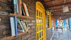 阿拉亚尔达茹达Pousada Simbiose的砖墙,有书,有黄色的门