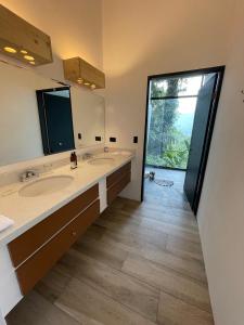 福尔图纳Sangregado Lodge的一间带两个盥洗盆的浴室和一个大窗户