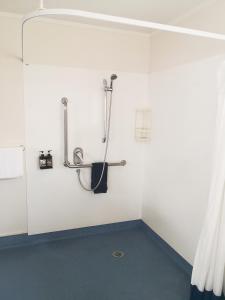 陶朗加Accommodation at Te Puna Motel的白色墙壁上带淋浴的浴室
