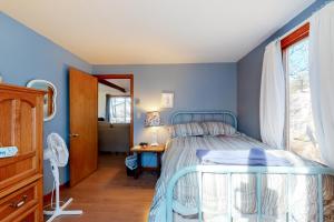 埃德加敦Wooded Oasis的一间卧室设有蓝色的墙壁、一张床和一张书桌