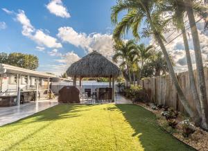 劳德代尔堡Tiki-home Elite Staycation的后院,带凉亭的草地庭院