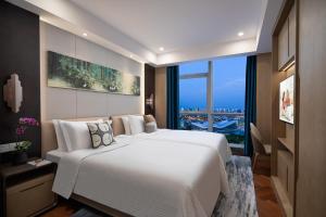 无锡无锡雅诗阁新发服务公寓的卧室设有一张白色大床和大窗户