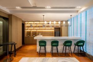 无锡无锡雅诗阁新发服务公寓的大堂设有带绿色椅子的酒吧