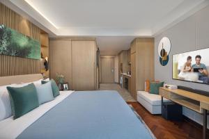 无锡无锡雅诗阁新发服务公寓的酒店客房设有一张大床和一台电视机。