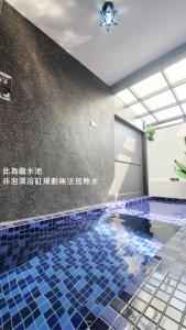 小琉球岛天台日光屋小琉球民宿的一个带蓝色瓷砖地板的游泳池