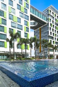 胡志明市Holiday Inn & Suites Saigon Airport, an IHG Hotel的大楼前的游泳池