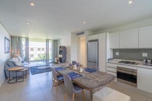 SibayaUnit 215 Oceandune - Stunning & Modern Apartment的厨房以及带桌椅的用餐室。