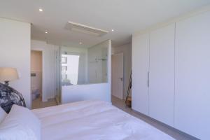 SibayaUnit 215 Oceandune - Stunning & Modern Apartment的卧室配有白色的床和镜子