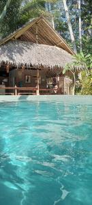 巴图卡拉RNV Eco Resort Bungalows的小屋前的蓝色水池