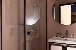 巴黎Paris Art Hotel Quartier Latin by Malone的带淋浴的浴室,配有水槽和镜子