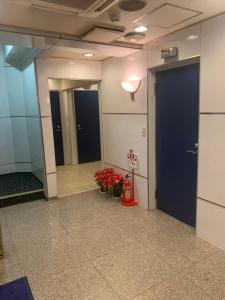 东京City Hotel Dolphin的带有两扇门和鲜花的办公大楼走廊