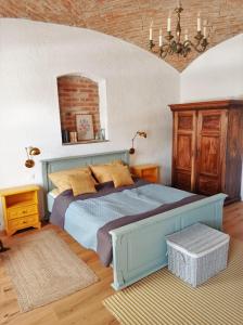 Kőszegszerdahely400 Éves Ház Vendégház的一间卧室设有蓝色的床和砖墙