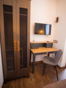 Colmenar de OrejaLos Tinajones的客房设有书桌、电视和椅子。