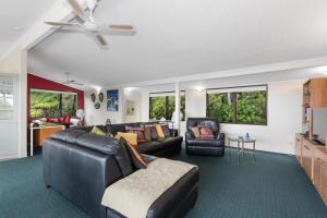 OpuaBreezy on Broadview - Opua Holiday Home的客厅配有真皮沙发和椅子