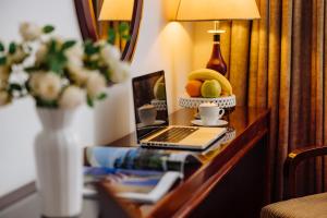 诺维萨德Garni Hotel Planeta Inn的一张带笔记本电脑的桌子和一个水果花瓶