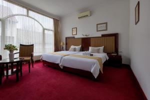 诺维萨德Garni Hotel Planeta Inn的酒店客房设有一张大床和一张桌子。