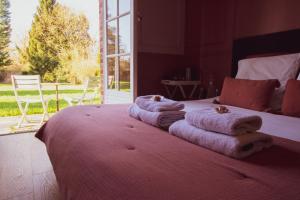 赫恩Les jardins de Beaumont的卧室配有带毛巾的床铺和大窗户